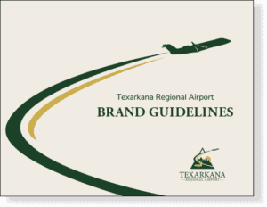 Mockup showing the cover page of the Texarkana Regional Airport brand guidelines, featuring a warm tan background with a evergreen airplane and a evergreen and gold trailing swoosh